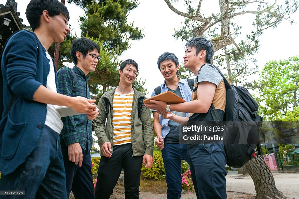 Estudantes japoneses com amigos verificando telefone em Kyoto, Japão