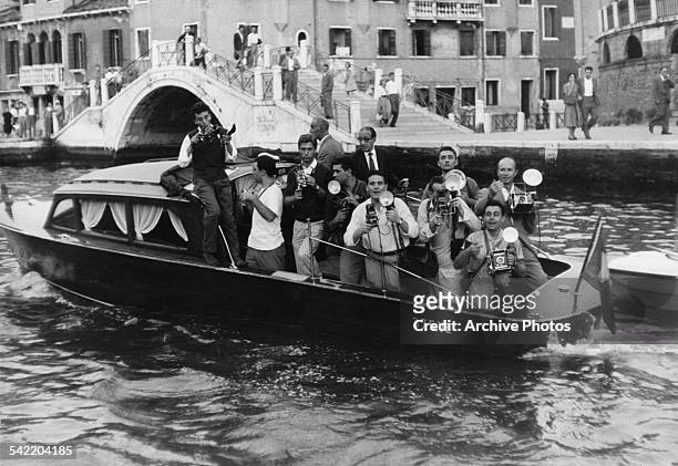 Motor launch filled with photographers following actress Brigitte Bardot and singer Sacha Distel down the canal during the Venice Film Festival,...
