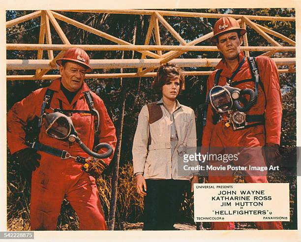 From left to right, actors John Wayne, Katharine Ross and Jim Hutton appear on the poster for the Universal Pictures film 'Hellfighters', 1968.