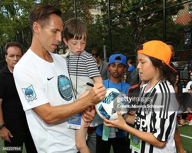 Retired professional basketball player and founder of the Steve Nash Foundation, Steve Nash accompanied by son Matteo Joel Nash, signs at autograph...