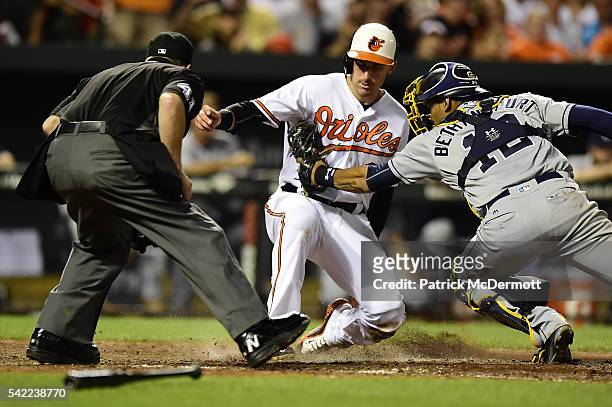 Ryan Flaherty of the Baltimore Orioles scores a run against Christian Bethancourt of the San Diego Padres on a single hit by Hyun Soo Kim of the...
