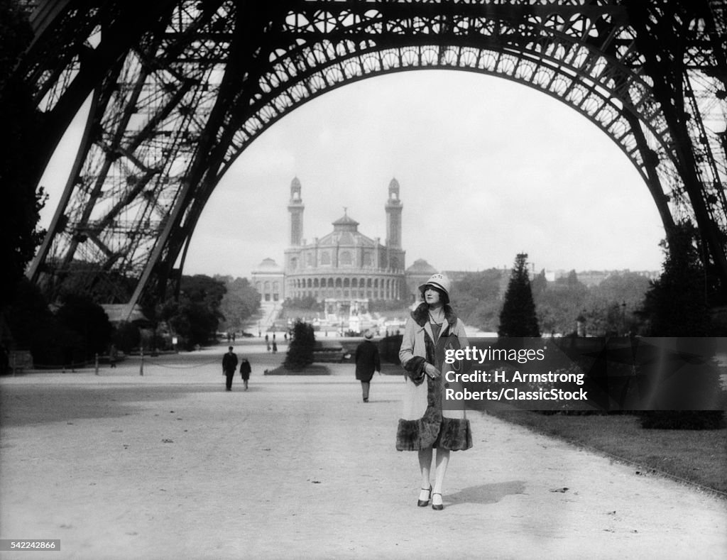 1920s WOMAN WALKING UNDER...