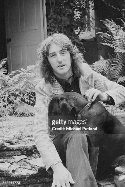Guitarist Denny Laine, of British rock group Wings, with a pet labrador, July 1975.