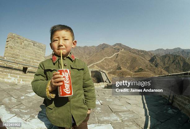 Chinese boy drinks a can of "Coca-Cola" on the Great Wall of China.