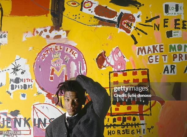 American artist, musician and producer of Haitian and Puerto Rican origins Jean-Michel Basquiat, in front of one of his paintings, during an...