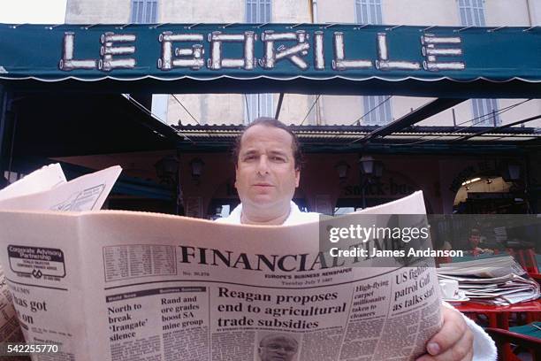 French writer and financier Paul Loup Sulitzer peruses "The Financial Times" at the well known Saint-Tropez cafe "Le Gorille". | Location: Saint...