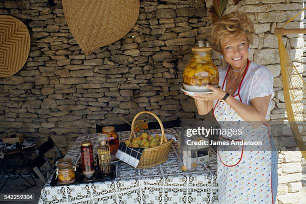 French journalist, screenwriter and actress France Roche preparing apricots in syrup in her Lubéron home during summer vacation.