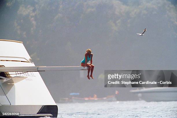 Lady Diana, Princess of Wales, sitting on the diving board of Mohammed Al Fayed's private yacht "Jonikal" as a seagull flies overhead.