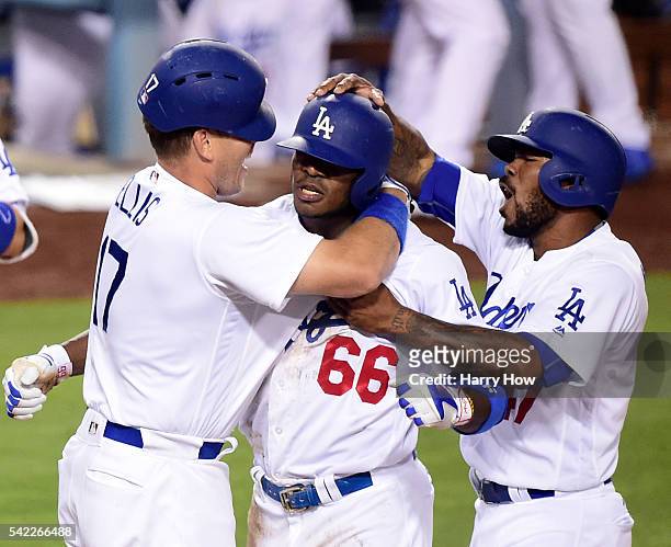 Yasiel Puig of the Los Angeles Dodgers celebrates his inside the park homerun with A.J. Ellis and Howie Kendrick to win the game 4-3 over the...