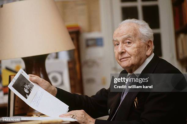French writer and poet Louis Aragon at home holding a photograph of himself with his partner, poet, translator and writer Elsa Triolet, in their...