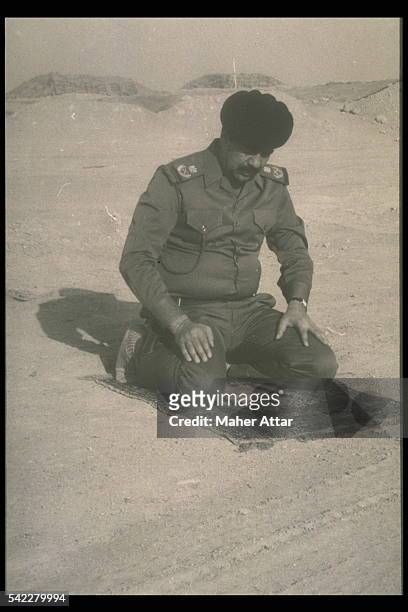 After Iraq's invasion of Kuwait, Saddam Hussein prays in the Kuwait desert.