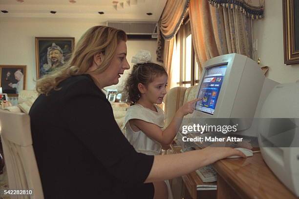 Soha Arafat in front of the computer helped by herdaughter Zahwa.