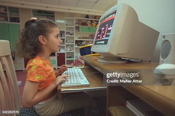 Zahwa Arafat playing on her computer in her room.