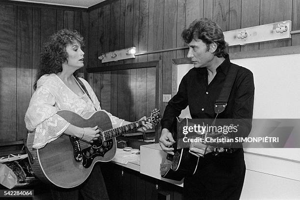 Johnny Hallyday playing with American singer and songwriter Emmylou Harris.