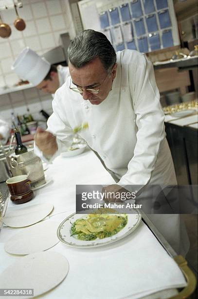 Alain Ducasse tasting a new dish in the kitchen at the Louis XV.
