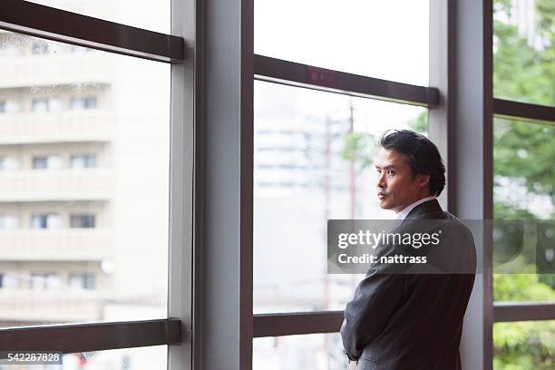 portrait of a young japanese business executive looking over shoulder - boss over shoulder stock pictures, royalty-free photos & images