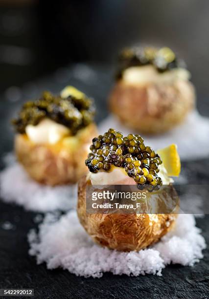 baked potatoes with black caviar - roes stock pictures, royalty-free photos & images
