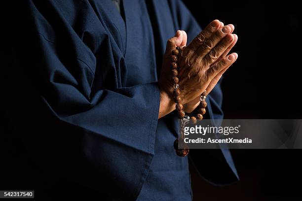 senior hands with prayer beads - buddhism stock pictures, royalty-free photos & images