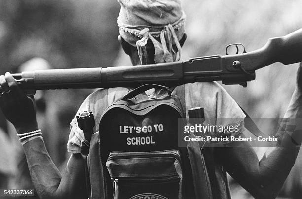 Kamajor fighter carries a rifle and ammunition in a backpack which says "Let's Go To School". The Kamajors are the only representatives of the civil...