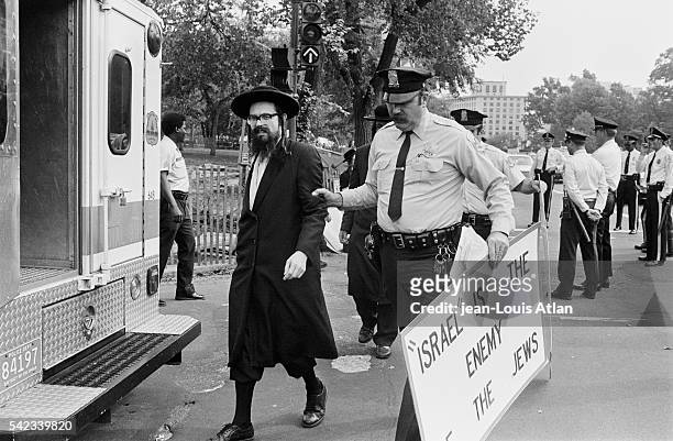 Police officer arrests a Jewish demonstrator, holding a sign reading "Israel is the Enemy of the Jews," during an anti-Israel protest in Washington,...