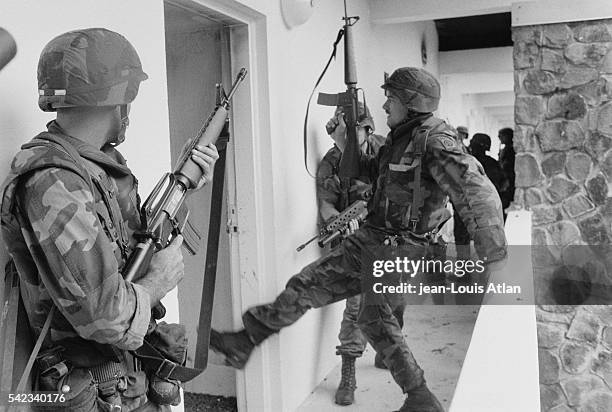 American soldiers search houses for possible enemies on the second day of the US invasion of Grenada. | Location: Grenada.