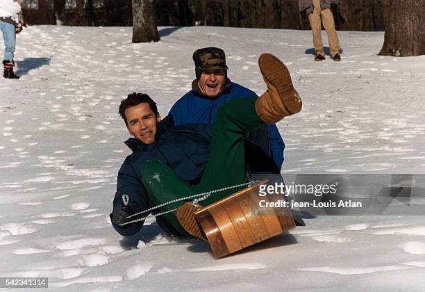 President George Bush takes a toboggan ride with Austrian actor Arnold Schwarzenegger at Camp David.