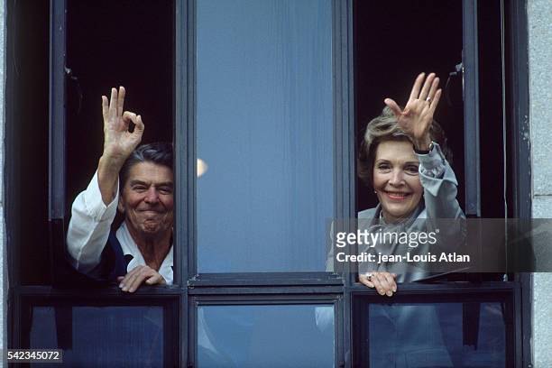 American President Ronald Reagan and wife Nancy wave from his room window at Bethesda hospital.