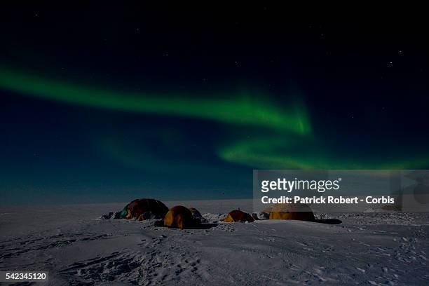 The Aurora Borealis glows in the sky above the base camp of the French High Risk Mountain Military Squad. The French High Risk Mountain Military...