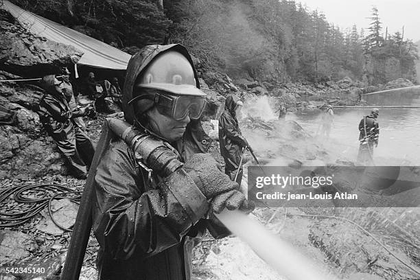 Teams of firefighters cleaning the Alaskan coast following the Exxon Valdez oil spill.