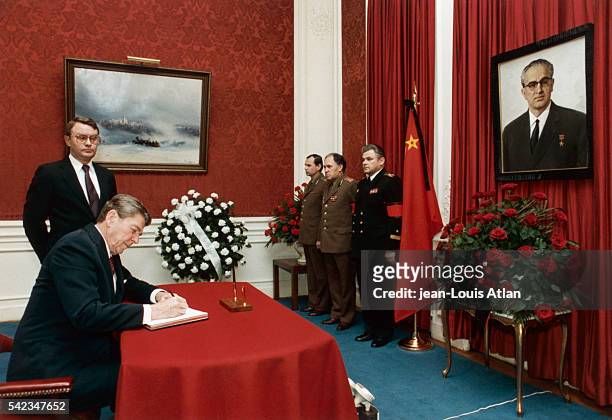 President Ronald Reagan signs the condolences book at the USSR embassy following the death of the Kremlin's leader.