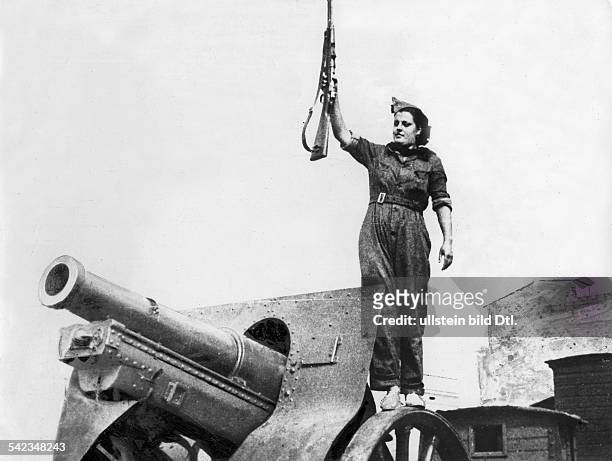 Spain : Spanish Civil War Member of a women's battalion with gun standing on a cannon - no place given - mid-August 1936 - Vintage property of...