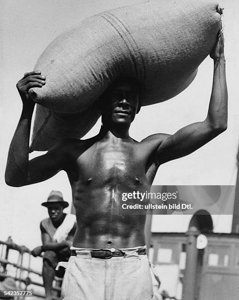 Serie: 'Vom Kaffee-Überfluss in Brasilien' 1932- Ein Mann trägt eine Sack mit Kaffeebohnen, die vernichtet werden sollen- Sommer 1932Foto: Martin...