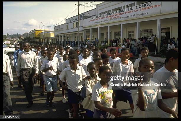 Schoolchildren parade in front of Laurent D{sir{ Kabila.