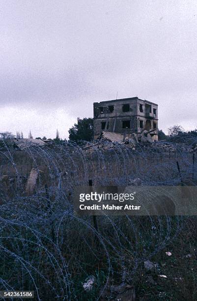 Destroyed buildings behind barbed wire, on the Syrian side of the Golan plateau.
