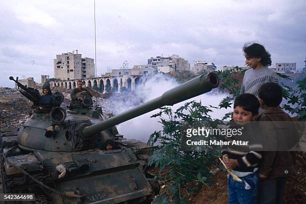 Women and her children stand near a T54 Syrian tank in Ras Elnabeh.