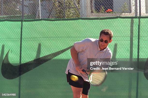 Nicolas Sarkozy playing tennis.