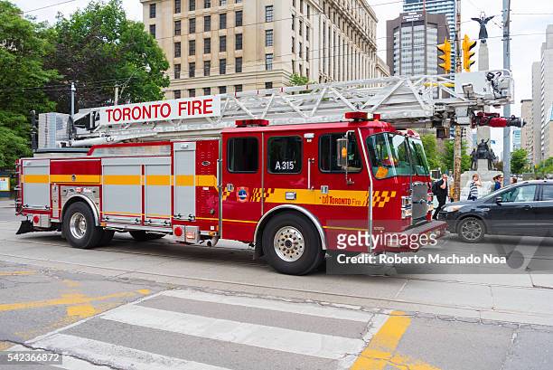 Toronto Fire Department truck going on an emergency call in day light. Cars making way to the sound of siren in downtown Toronto.