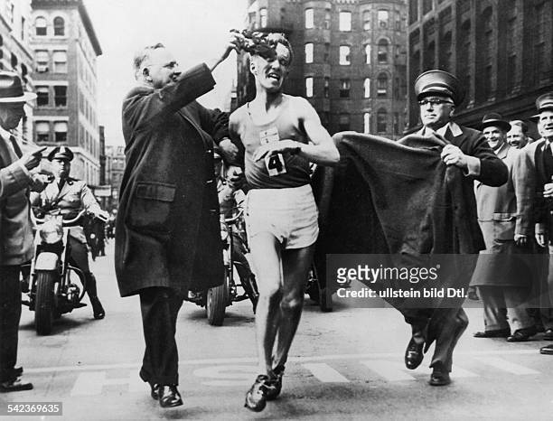 Anti Viskari , Sieger beim BostonerMarathonlauf; Bürgermeister Hynes drücktihm den Lorbeerkranz auf die Stirn.- 21.4.1956