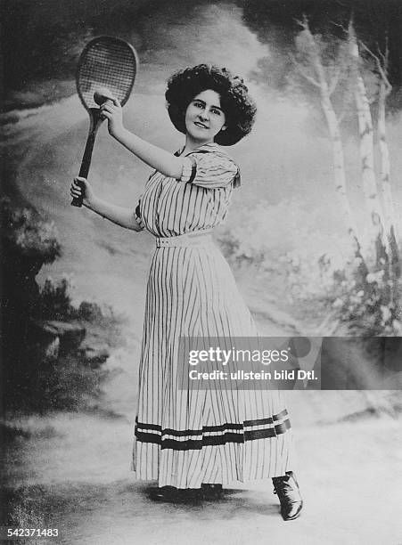 Die SchauspielerinGudrun Hildebrandt in einem gestreiftenKleid mit Tennisschläger und Tennisballvor einer Naturkulisse- ca. 1910Foto: Berliner...