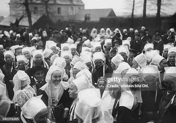 Massenhochzeit in Plougastel-Daoulas, Bretagne: Die Bräute versammeln sich vor der Zeremonie auf der einen Seite des Kirchplatzes.- Januar 1910Foto:...