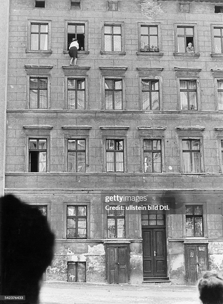 Germany, Berlin wallEscapes and escape attempts from East Germany Escape of a family of 3 persons from a building at 'Bernauer Street' that is situated right on the borderline between West and East Berlin; the woman standing on the ledge is waiting f