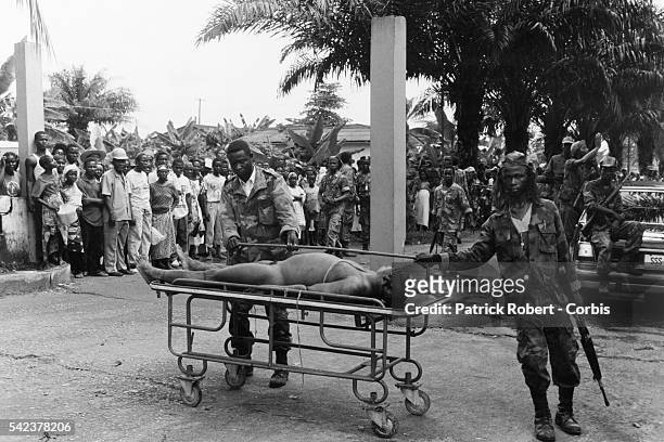 Liberian soldiers display the dead body of President Samuel Doe during the Liberian Civil War. Prince Yormie Johnson, leader of the Independent...