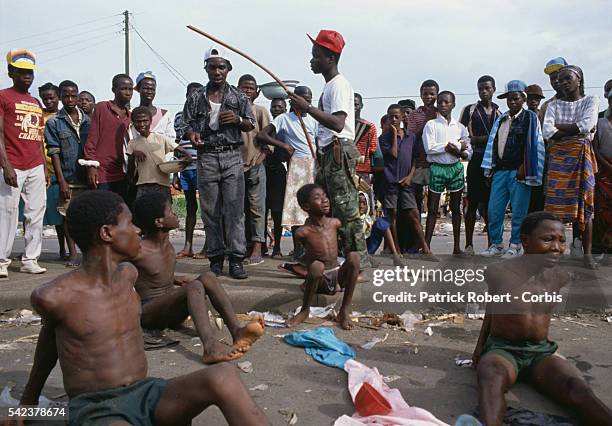 Young children accused of stealing are beaten in the streets of Monrovia by a member of the Independent National Patriotic Front of Liberia ....