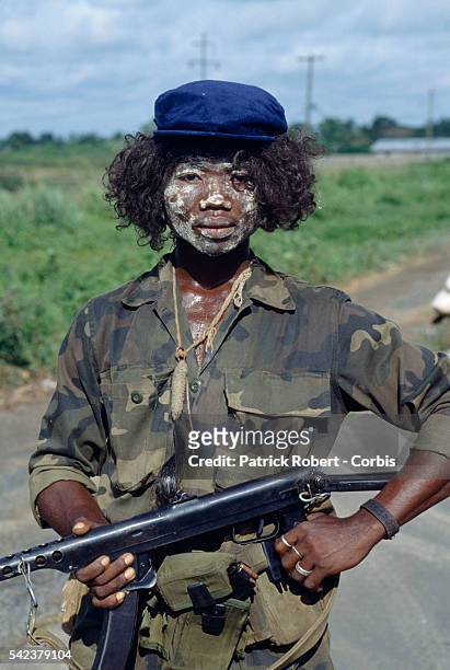 Member of the Independent National Patriotic Front of Liberia covers his face in paint, an act often done by rebel forces for spiritualistic reasons...
