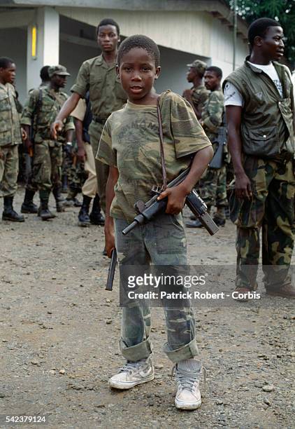 Young child, one of many coerced into serving with the rebel factions, is part of the escort of Prince Yormie Johnson, leader of the militant group...