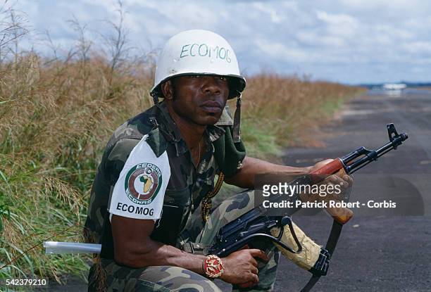 Soldier from the multinational West African peacekeeping forces of ECOMOG protects Monrovia's Spriggs Payne Airport from rebel factions. Responding...