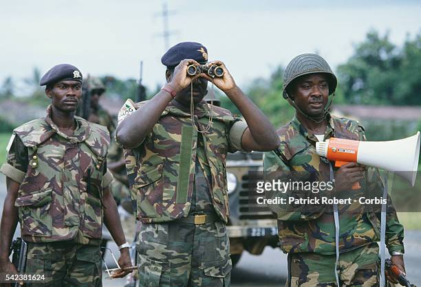 Soldiers on patrol look down a road in Monrovia. Charles Taylor, leader of the NPFL , launched a revolt against the regime of Samuel Doe at the end...