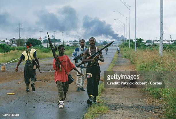 Armed young men patrol a road in Monrovia during the Liberian Civil War. In 1989, Charles Taylor, leader of the NPFL , launched a revolt against the...