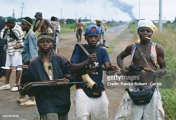 Young rebel fighters pose with their assault rifles in Monrovia during the Liberian Civil War. In 1989, Charles Taylor, leader of the NPFL , launched...