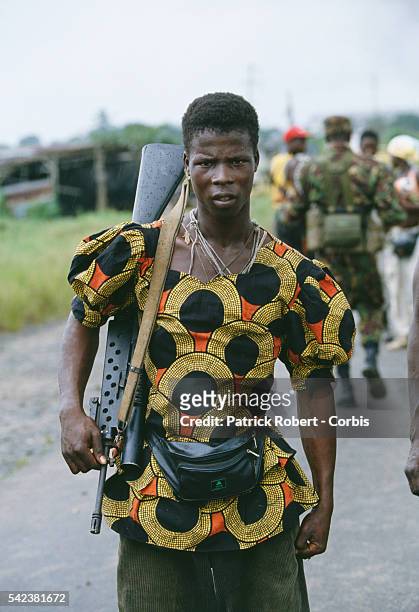 Rebel fighter in Monrovia wears a colorful shirt and holds a rifle during the Liberian Civil War. In 1989, Charles Taylor, leader of the NPFL ,...